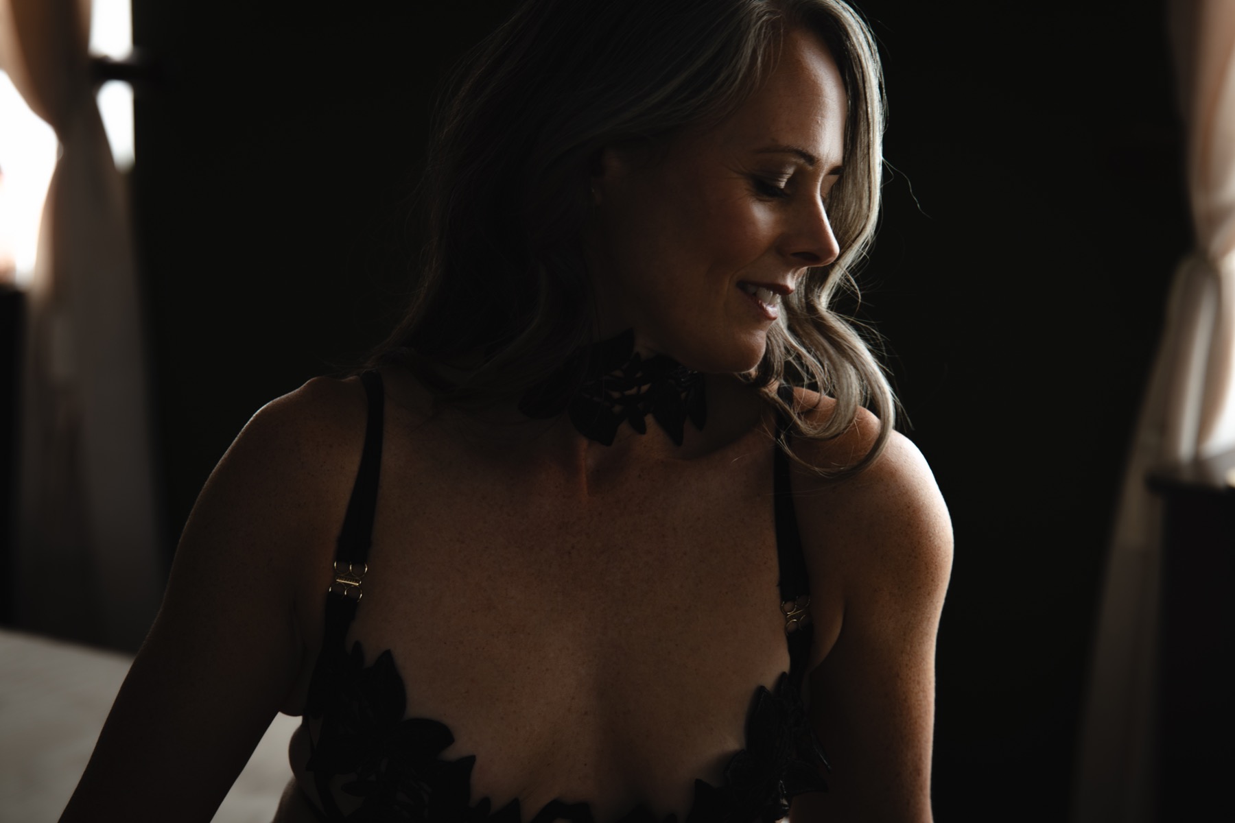 A client smiling in profile in soft window light